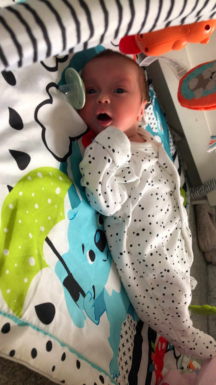 Isaac joined the competition — help win amazing prizes! baby, infant, onesie, polka_dots, playmat, blue_bear, green_umbrella, pacifier, orange_toy, lying_down, curious_expression, indoor, soft_toys, child, newborn, colorful, fabric, cute, face, early_childhood