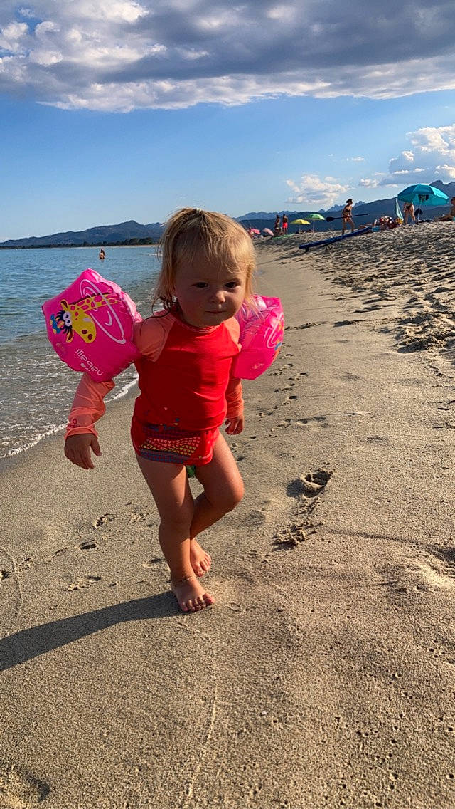 Alba a rejoint le concours — aidez-le/la à gagner de superbes lots ! beach, cloud, coastal_and_oceanic_landforms, fun, happy, holiday, leisure, natural_environment, people_in_nature, people_on_beach, person, pink, sand, shore, sky, summer, sunlight, toddler, travel, water