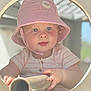 toddler, child, hat, bucket_hat, pink, striped, face, blue_eyes, hands, metal_tube, circle_frame, curious, outdoor, soft_light, portrait, baby, clothing, person, skin, candid