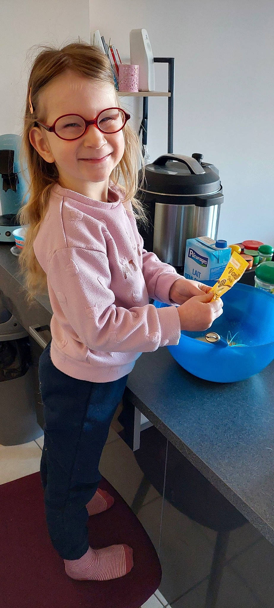 Nola a rejoint le concours — aidez-le/la à gagner de superbes lots ! child, cooking, electric_blue, eyewear, fun, glasses, home_appliance, homemaker, jeans, joy, kitchen, kitchen_appliance, person, room, sitting, sleeve, smile, t_shirt, table, tableware