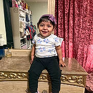 Juliette joined the competition — help win amazing prizes! toddler, child, smile, happy, sitting, headband, purple, flower_pattern, shirt, black_pants, pink_shoes, dresser, mirror, curtains, room, clothes, reflection, indoor, furniture, person