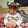 Juliette joined the competition — help win amazing prizes! child, girl, pigtails, hair_ties, sweater, pink_pants, bed, blankets, hair_clip, hands, indoor, portrait, cute, young_child, toy, furniture, curtains, wood, cozy, focused