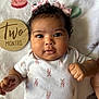 adorable, baby, baby_girl, blanket, chubby_cheeks, close_up, curly_hair, cute, face, fist, headband, indoors, infant, infant_clothing, lying_down, onesie, portrait, sleeping_mat, soft_texture, two_months