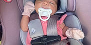 Athena is registered to the contest to win money with this photo: baby, car_seat, pacifier, mittens, sleeping, child, infant, seatbelt, pink_clothing, safety, closeup, indoors, young_child, resting, soft_fabric, head_support, cute, toddler, relaxation, comfort