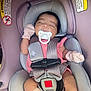 baby, car_seat, pacifier, mittens, sleeping, child, infant, seatbelt, pink_clothing, safety, closeup, indoors, young_child, resting, soft_fabric, head_support, cute, toddler, relaxation, comfort