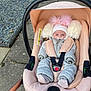 Millie Mae is registered to the contest to win money with this photo: baby, stroller, pacifier, hat, pom_poms, coat, baby_clothes, outdoor, sidewalk, gravel, pavement, infant, child, seat_belt, car_seat, pink, gray, winter_clothing, warm, bundle