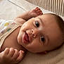 baby, infant, smile, face, onesie, fruit_pattern, blanket, soft_texture, lying_down, happy, cute, child, skin, head, hand, indoors, cozy, expression, portrait, closeup