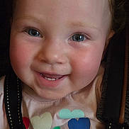 Coriann is registered to the contest to win money with this photo: baby, toddler, child, smiling, portrait, face, eyes, hair, stroller, harness, seated, indoor, close_up, happy, clothing, hearts, colorful, hands, photography, joy