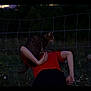 cat, person, red_shirt, wire_fence, sheep, dusk, outdoor, wildflowers, animal, grass, nature, rural, tabby_cat, back_view, shoulders, pet, evening, field, animal_companion, quiet