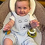 baby, baby_seat, blond_hair, blue_clothing, child, cushion, cute, face, hands, happy, indoor, infant, mesh, overalls, portrait, seat_belt, skin, smiling, toy, young_child