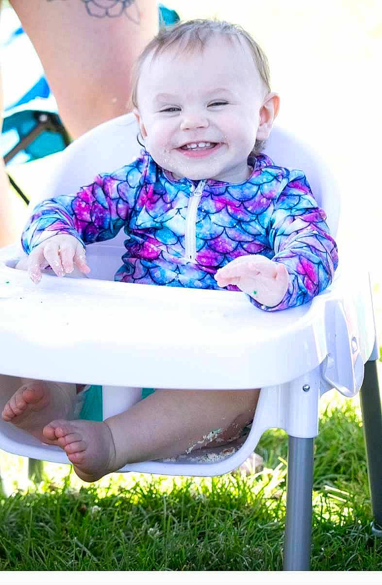 Georgia is registered to the contest to win money with this photo: baby, baby_toddler_clothing, chair, child, electric_blue, facial_expression, fun, grass, happy, joy, leisure, magenta, people, person, pink, purple, smile, summer, t_shirt, table