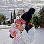 baby, woman, snow, winter_clothing, outdoor, kiss, love, cloudy_sky, trees, house, plants, jacket, hat, pink_booties, sleeping_baby, holding, portrait, suburb, nature, affection