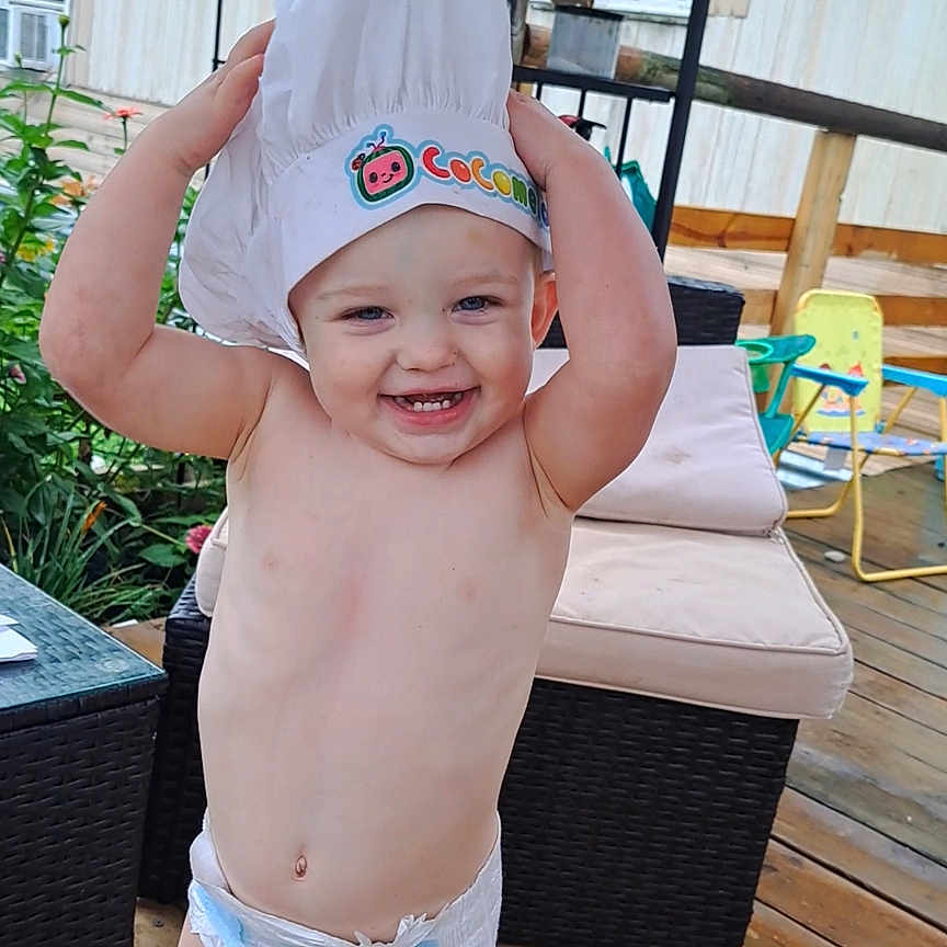 Axton is registered to the contest to win money with this photo: architecture, baseballcap, building, cap, clothing, face, hat, head, house, housing, indoors, person, photography, plant, porch, portrait, pottedplant, shorts, swimwear, wood