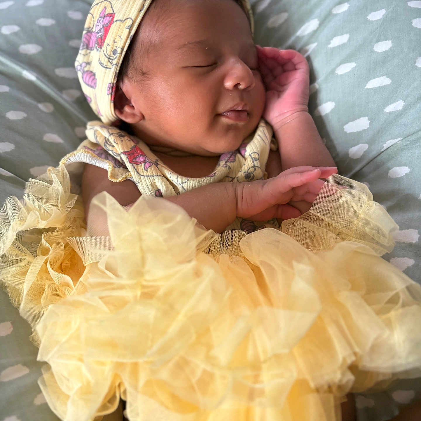 Analaya is registered to the contest to win money with this photo: adorable, baby, child, closeup, clothing, cushion, cute, face, headband, indoors, infant, pattern, peaceful, portrait, relaxed, resting, sleeping, soft, tutu, yellow