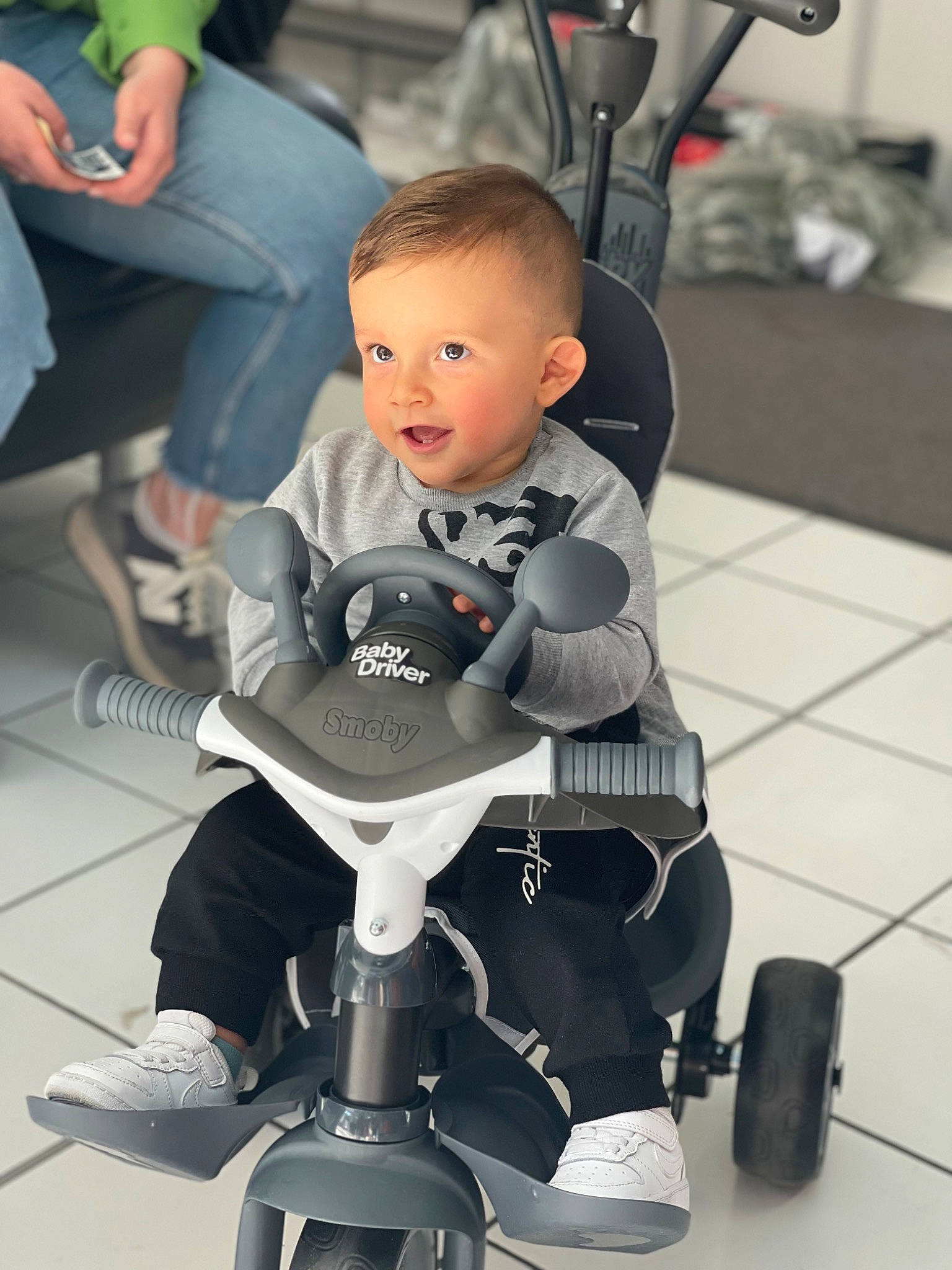 Ismael a rejoint le concours — aidez-le/la à gagner de superbes lots ! auto_part, automotive_design, automotive_tire, baby, baby_carriage, black, chair, comfort, flooring, green, human_leg, joint, knee, lap, leg, person, rolling, tire, toddler, wheel