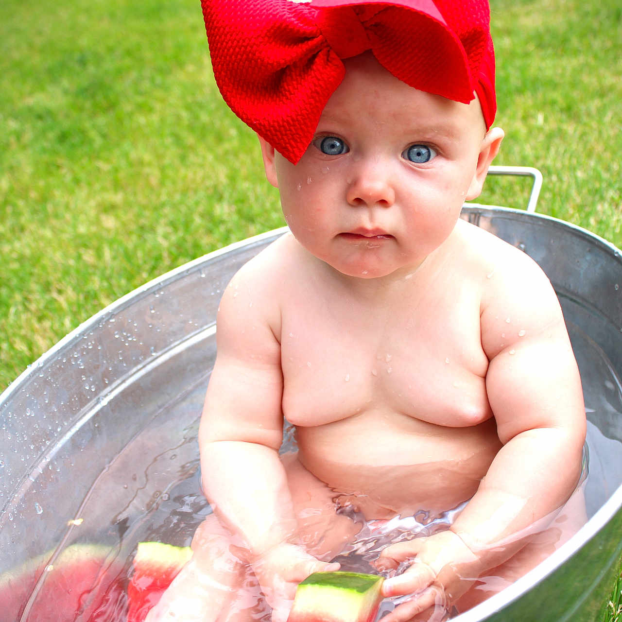 Marceline joined the competition — help win amazing prizes! baby, blue_eyes, bow, child, cute, drink, face, fresh, grass, green, hand, metal_tub, outdoor, person, pool, red_bow, sitting, summer, water, watermelon