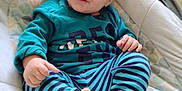 Kasson is registered to the contest to win money with this photo: baby, baby_seat, barefoot, child, clothing, cushion, cute, face, floor, foot, hand, happy, head, indoor, infant, person, portrait, smiling, striped_pants, teal_shirt