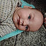 baby, infant, face, polka_dot, clothing, foot, toenail_paint, sandals, carpet, floor, towel, person, skin, head, eyes, mouth, indoor, casual, closeup, cute