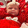 Mckenna joined the competition — help win amazing prizes! baby, infant, newborn, face, headband, bow, red_dress, ruffled_dress, blanket, floral_pattern, fabric, portrait, close_up, eyes, cheeks, smile, rosy_cheeks, soft_light, indoors, adorable