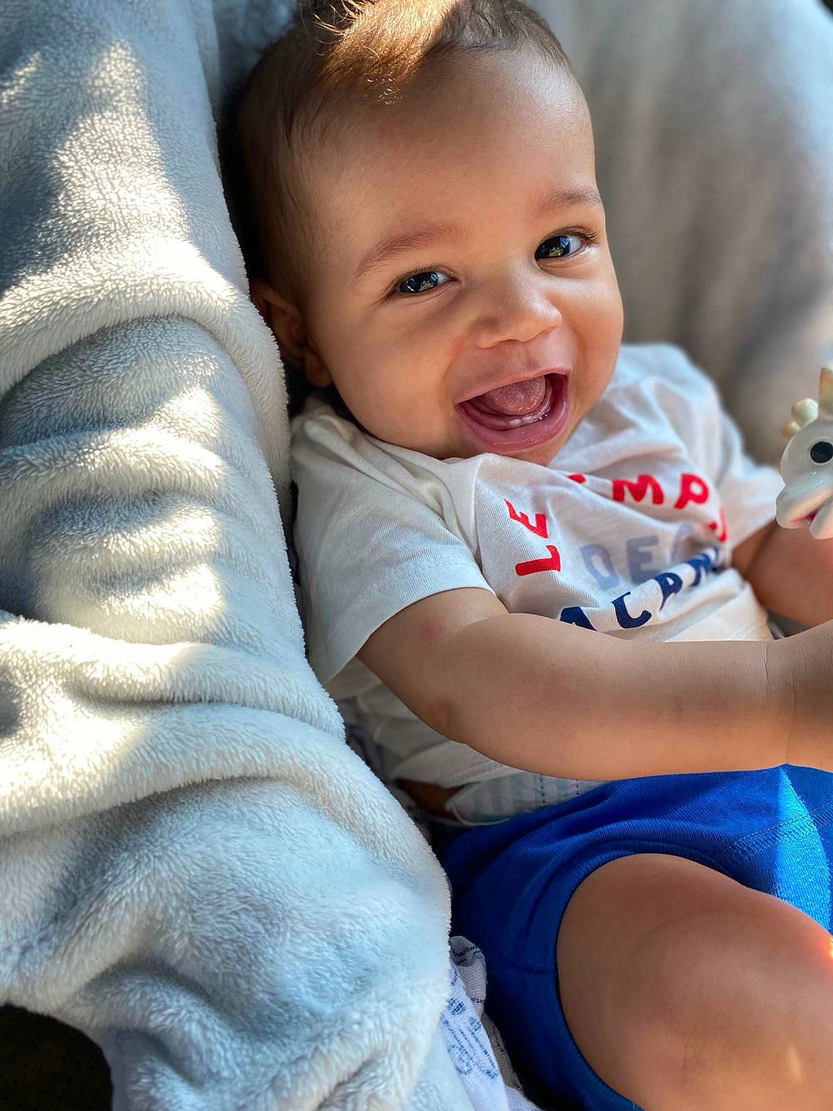 Eliott participe au concours pour gagner de l'argent avec cette photo : arm, baby, baby_toddler_clothing, cheek, child, comfort, eye, face, finger, grass, happy, head, human_body, iris, mouth, nose, person, skin, smile, thigh