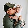 baby, person, kiss, smile, headband, cap, glasses, affection, love, holding, portrait, indoor, cute, child, family, tender, happy, light, casual, clothing