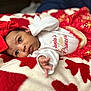 baby, infant, red_bow, white_onesie, red_skirt, blanket, holiday_theme, cute, portrait, face, hand, lying_down, cozy, soft_texture, christmas, child, young, small, adorable, festive