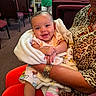 baby, infant, blanket, smile, person, arm, clothing, jewelry, leopard_print, socks, indoor, chair, carpet, people, background, holding, cute, happy, toddler, portrait