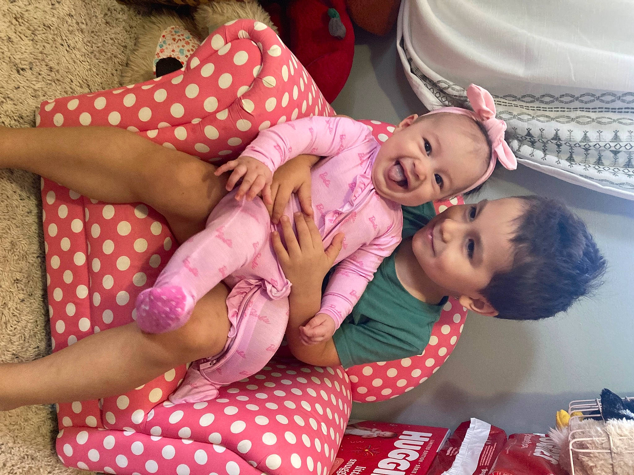 Emma is registered to the contest to win money with this photo: baby, baby_toddler_clothing, child, comfort, event, facial_expression, finger, fun, hand, happy, joy, lap, leg, nail, pattern, person, pink, sitting, skin, smile