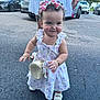Daphne Nicolle is registered to the contest to win money with this photo: toddler, child, girl, dress, headband, purse, shoes, outdoor, pavement, toy, adult, hand, car, parking_lot, smile, cute, walking, summer, accessory, flower_pattern
