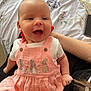 Gracie is registered to the contest to win money with this photo: baby, smiling, pink_dress, bunny, embroidery, child, person, sitting, happy, indoor, bedspread, floral_pattern, phone, hand, arm, clothing, cute, portrait, infant, skin