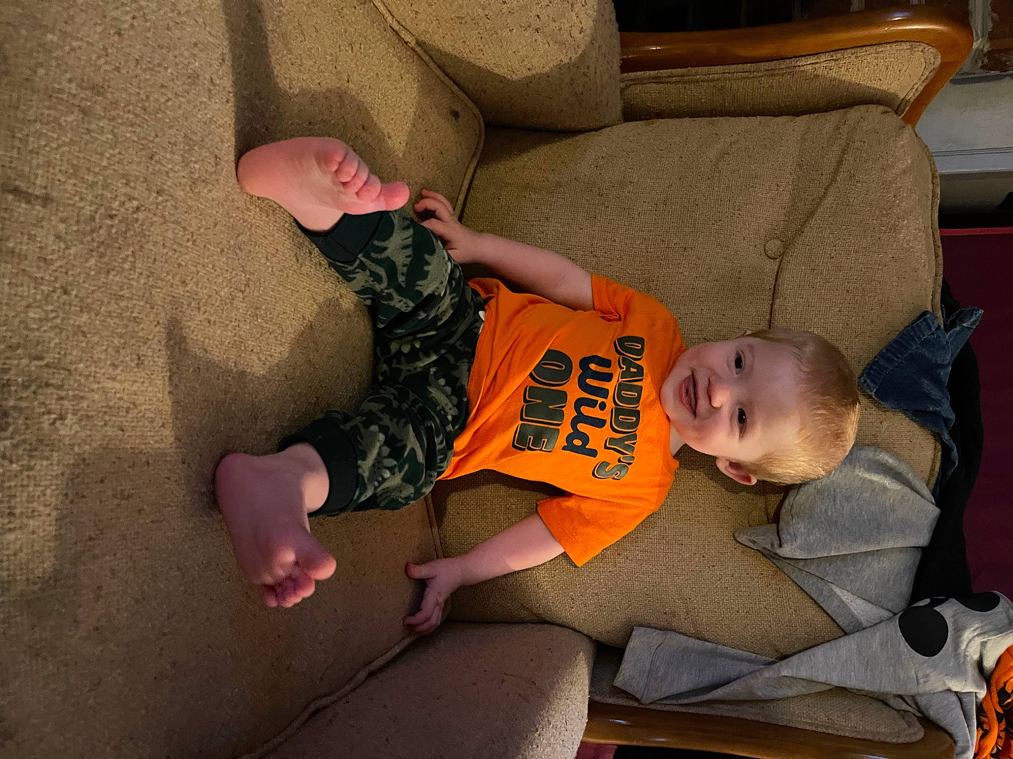 Ashton is registered to the contest to win money with this photo: arm, baby, baby_carriage, baby_products, baby_toddler_clothing, child, comfort, couch, fun, human_leg, knee, lap, leg, linens, person, sitting, sock, thigh, toddler, tree