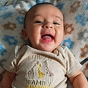 Osias joined the competition — help win amazing prizes! baby, smiling, infant, face, clothing, shirt, giraffe, text, blanket, pattern, happy, tongue, cute, child, portrait, lying_down, closeup, skin, person, indoors