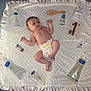 baby, diaper, cream, blanket, baby_care_products, wooden_brush, card, number_one, teddy_bear, satin_edge, soft_texture, infant, child, skin_care, mustela, lying_down, curious_expression, indoor, baby_brush, one_month