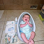 Hosanna a rejoint le concours — aidez-le/la à gagner de superbes lots ! baby, infant, smiling, plastic_seat, tiled_floor, diapers, towel, baby_lotion, onesie, clapping_hands, happy, indoors, child, floor, baby_care, baby_clothing, baby_bath, cute, joyful, small_seat