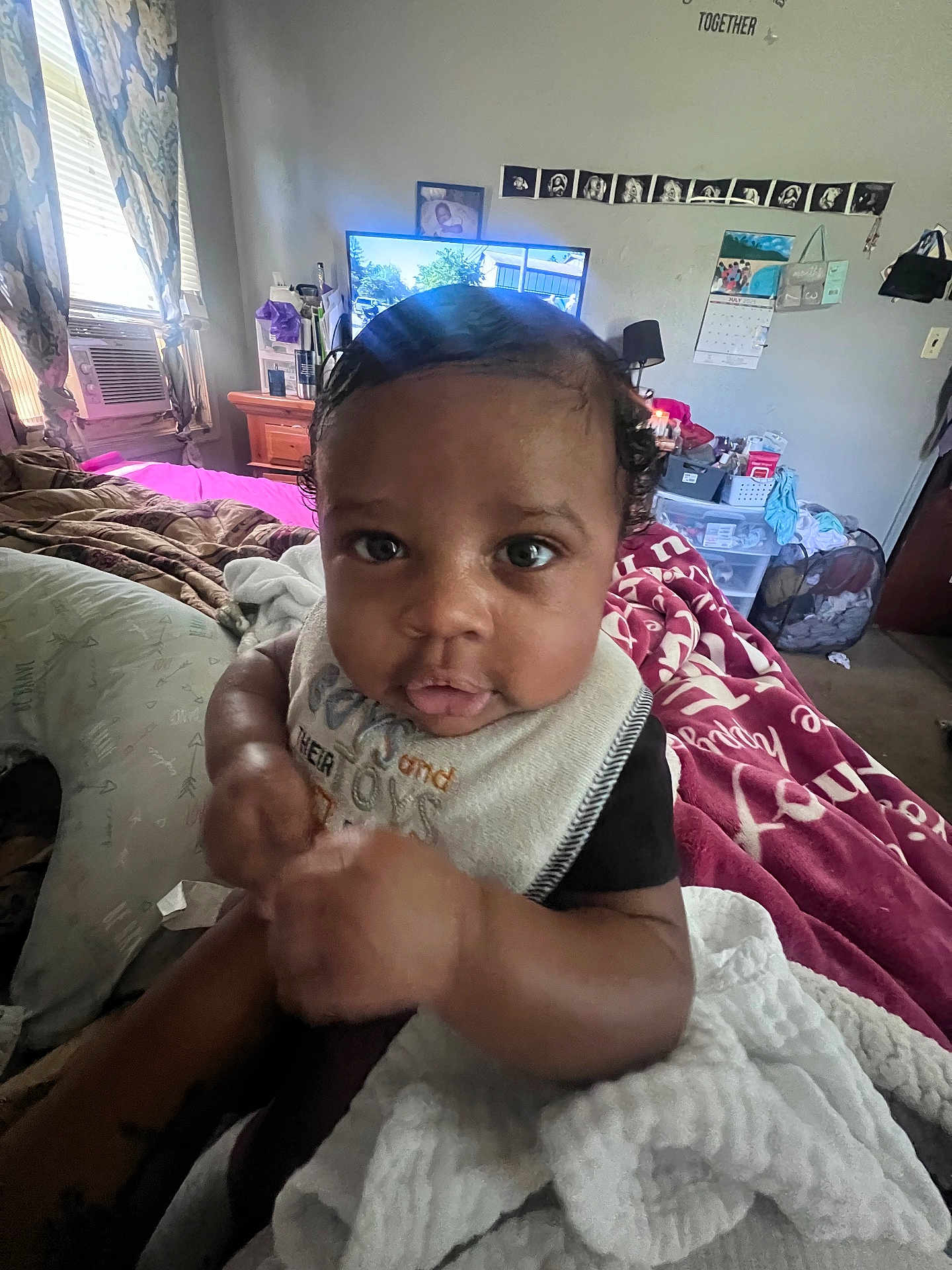 Kaizen is registered to the contest to win money with this photo: baby, infant, child, bed, blanket, pillow, room, window, curtains, television, furniture, calendar, bib, person, indoor, clothing, face, hair, hand, expression