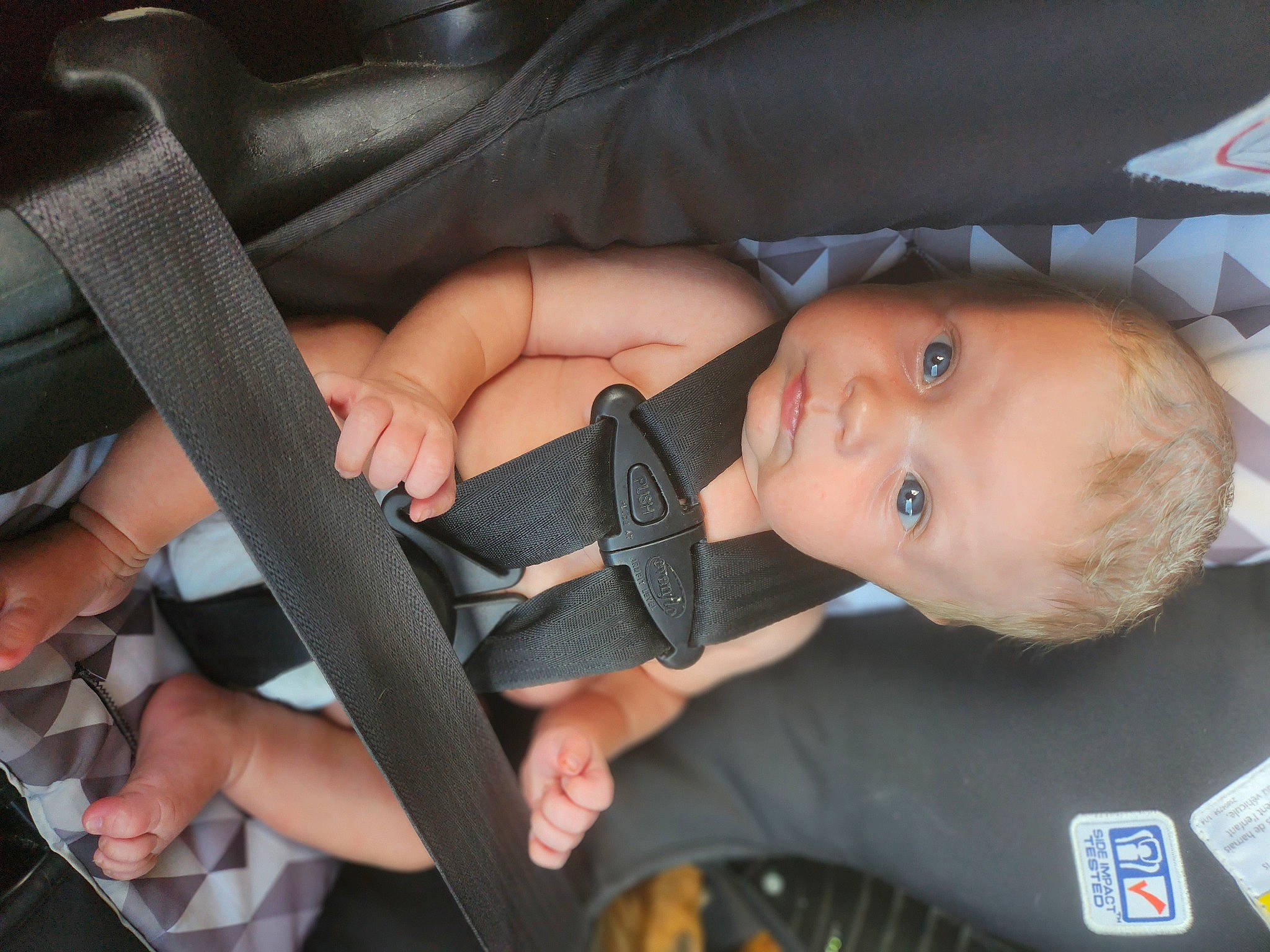 Travis is registered to the contest to win money with this photo: auto_part, baby, baby_carriage, baby_products, baby_toddler_clothing, car_seat, child, comfort, finger, gesture, hand, nail, person, personal_protective_equipment, product, seat_belt, sitting, thumb, toddler, vehicle_door