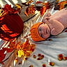 baby, infant, child, portrait, lying_down, orange_hat, knitted_hat, autumn, fall, pumpkin, leaves, bed, blanket, indoor, sunlight, shadows, cozy, seasonal, sleeping, closeup