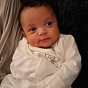 Cru Louie is registered to the contest to win money with this photo: baby, bed, blanket, bodypart, bonnet, clothing, face, finger, furniture, hand, hat, head, knitwear, longsleeve, newborn, person, photography, portrait, shirt, sleeve