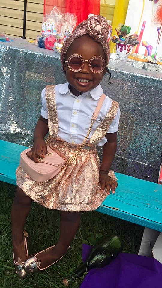 Amaria joined the competition — help win amazing prizes! adaptation, child, dress, fun, glasses, joy, person, sitting, smile, toddler