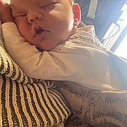 Dawson is registered to the contest to win money with this photo: baby, sleeping, blanket, clothing, person, indoor, closeup, face, peaceful, rest, warmth, comfort, soft, newborn, child, portrait, casual, holding, relaxation, gentle