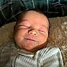 baby, newborn, sleeping, smile, face, infant, child, soft, blanket, striped_clothing, cozy, cute, peaceful, portrait, indoor, closeup, relaxed, human, skin, head