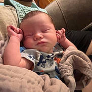 Dawson is registered to the contest to win money with this photo: baby, blanket, sleeping, couch, wooden_wall, infant, person, cozy, indoor, comfort, soft, rest, peaceful, child, clothing, relaxation, home, nap, furniture, portrait