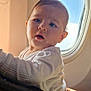 Lorenzo a rejoint le concours — aidez-le/la à gagner de superbes lots ! baby, infant, child, airplane, airplane_window, seatbelt, person, face, curious, white_clothing, natural_light, travel, traveling, inside_airplane, window, portrait, holding, closeup, soft_light, young_child