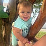 toddler, child, smiling, tree, branches, outdoor, nature, person, holding, clothing, pink_socks, light_blue_shirt, face, happy, young_child, skin, arm, tattoo, blurred_background, daylight