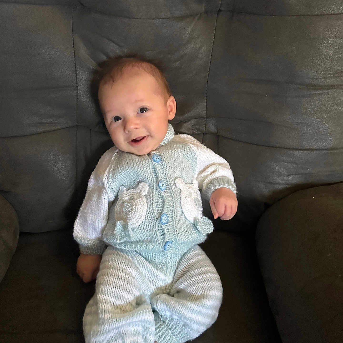 Sy Mir is registered to the contest to win money with this photo: baby, buttoned_sweater, casual, chair, child, comfort, couch, cozy, cute, face, feet, happy, head, indoor, infant, knitted_clothing, portrait, sitting, smiling, young