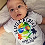Liam joined the competition — help win amazing prizes! baby, infant, face, tshirt, clothing, colorful, skull, palm_tree, lying_down, child, cute, expression, indoors, soft_surface, portrait, young_child, closeup, head, person, apparel