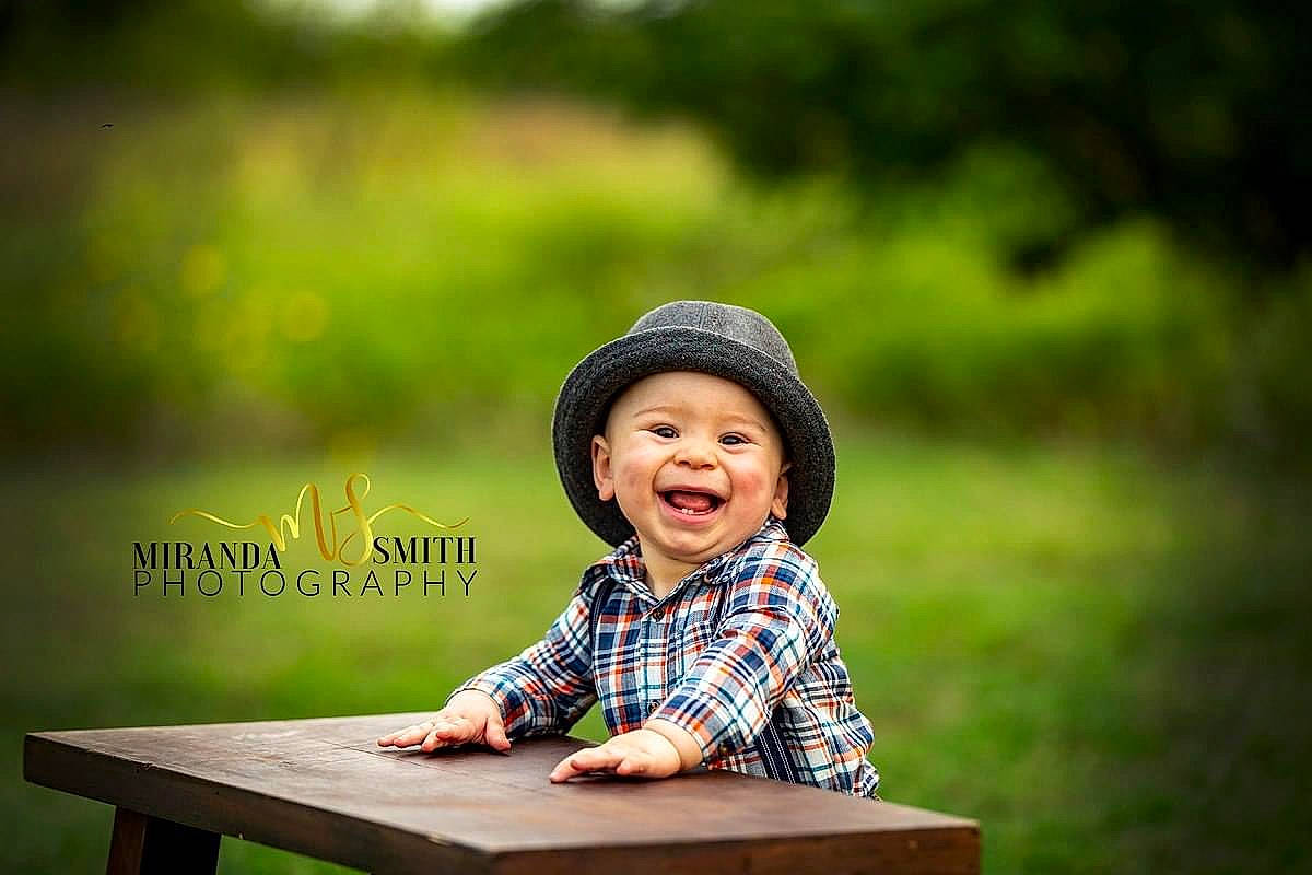 Jasiah is registered to the contest to win money with this photo: baby, child, child_model, facial_expression, fun, grass, happy, headgear, headwear, joy, laugh, leisure, person, photograph, photography, portrait, portrait_photography, sitting, smile, stock_photography