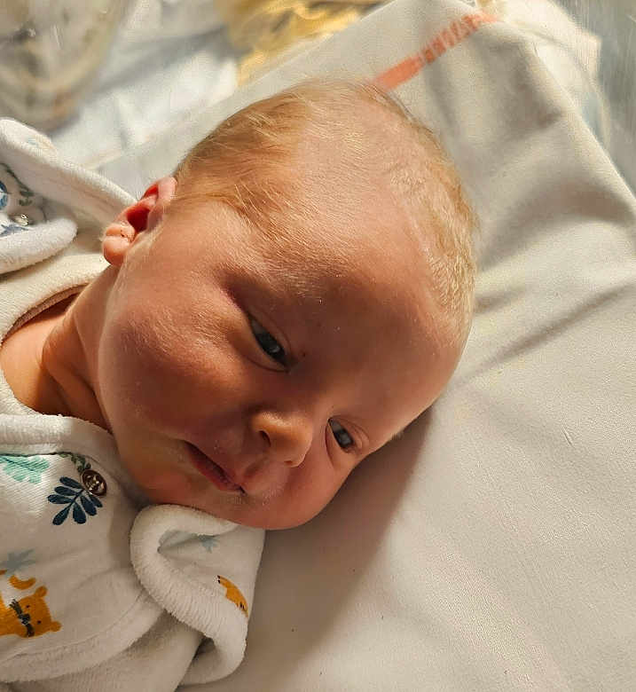 Augustin participe au concours pour gagner de l'argent avec cette photo : baby, infant, newborn, face, lying_down, blanket, onesie, clothing, cute, soft_lighting, peaceful, close_up, skin, head, expression, indoors, child, sleepy, portrait, young