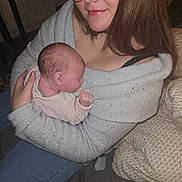 éloïse participe au concours pour gagner de l'argent avec cette photo : affection, baby, bedroom, blanket, casual_clothing, comfort, face, family, glasses, hair, holding, indoor, newborn, person, pillow, seated, skin, smile, woman, young