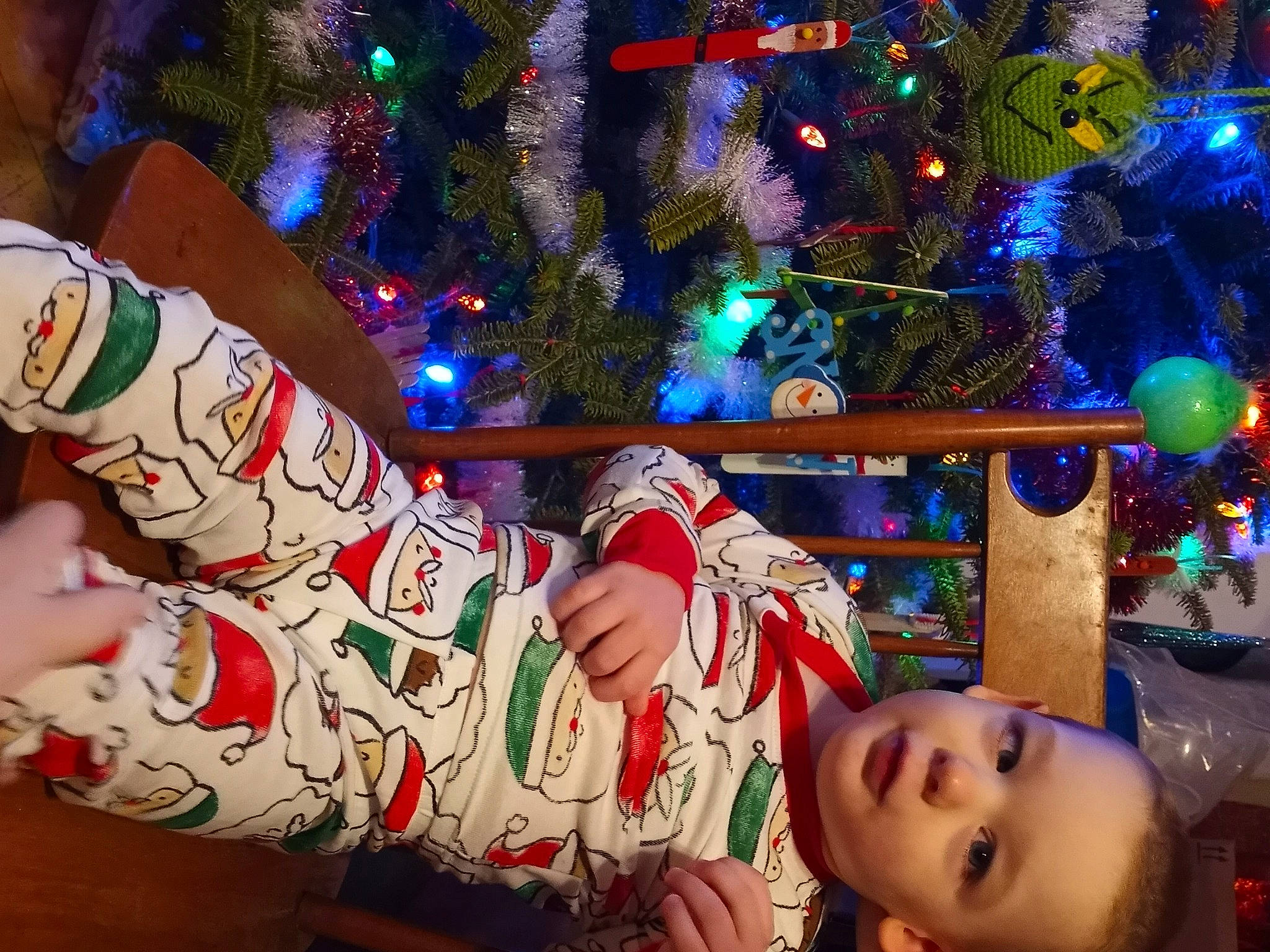 Leo is registered to the contest to win money with this photo: child, christmas, christmas_decoration, christmas_eve, christmas_ornament, christmas_tree, event, foot, fun, happy, holiday, holiday_ornament, human_body, human_leg, lap, light, ornament, person, thigh, tradition